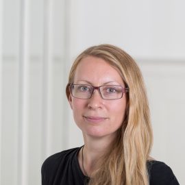 Portrait photo of a blonde woman wearing glasses